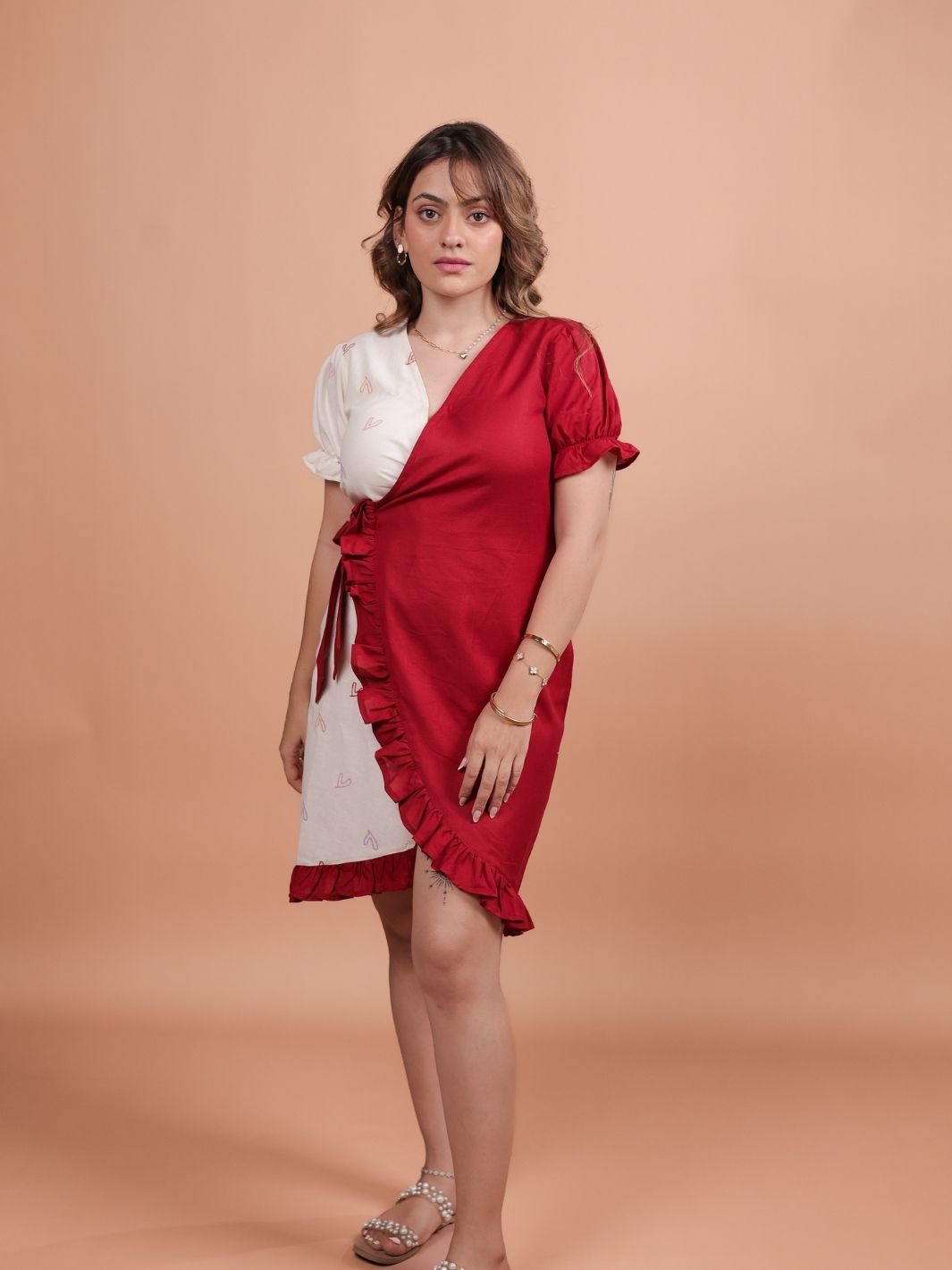 Hearts Red Ruffle Wrap Dress featuring a playful heart print, flattering ruffle design, and adjustable wrap closure.