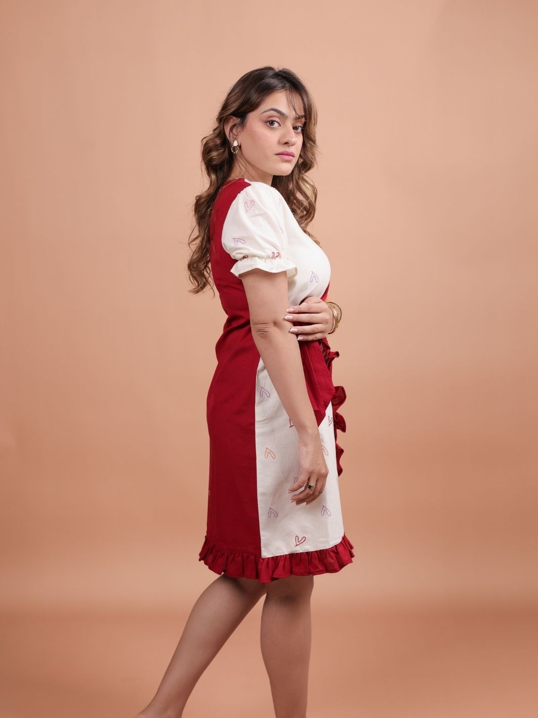 Hearts Red Ruffle Wrap Dress featuring a playful heart print, flattering ruffle design, and adjustable wrap closure.