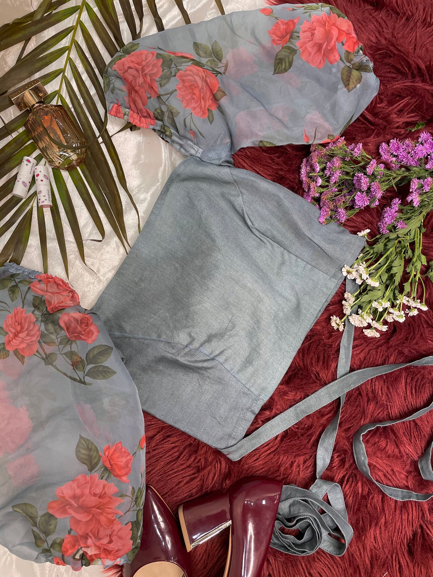 Forget Me Not Blueish Grey Crop Top made from vibrant floral organza fabric, featuring balloon sleeves and criss-cross embellishing straps for a stylish midriff look. Perfect for any occasion, this gorgeous crop top combines elegance with modern flair.